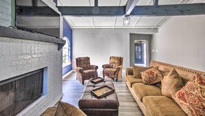 A spacious living room with a fireplace, leather ottoman, and two patterned armchairs. - Lakefront Family Home, Recently Renovated! (Trinidad)