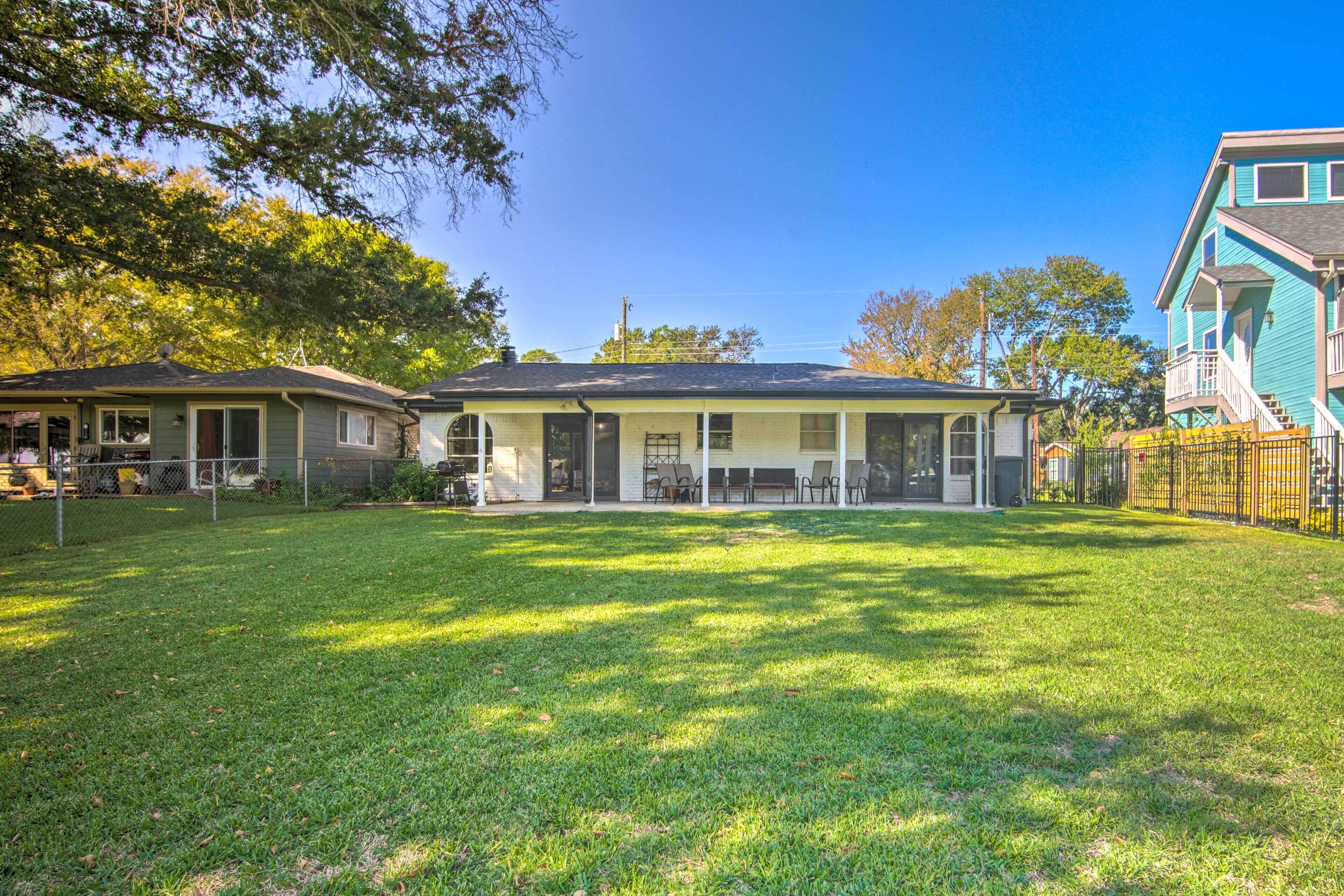 A two-story house with a covered patio and a fenced yard.
