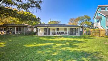 A two-story house with a covered patio and a fenced yard.