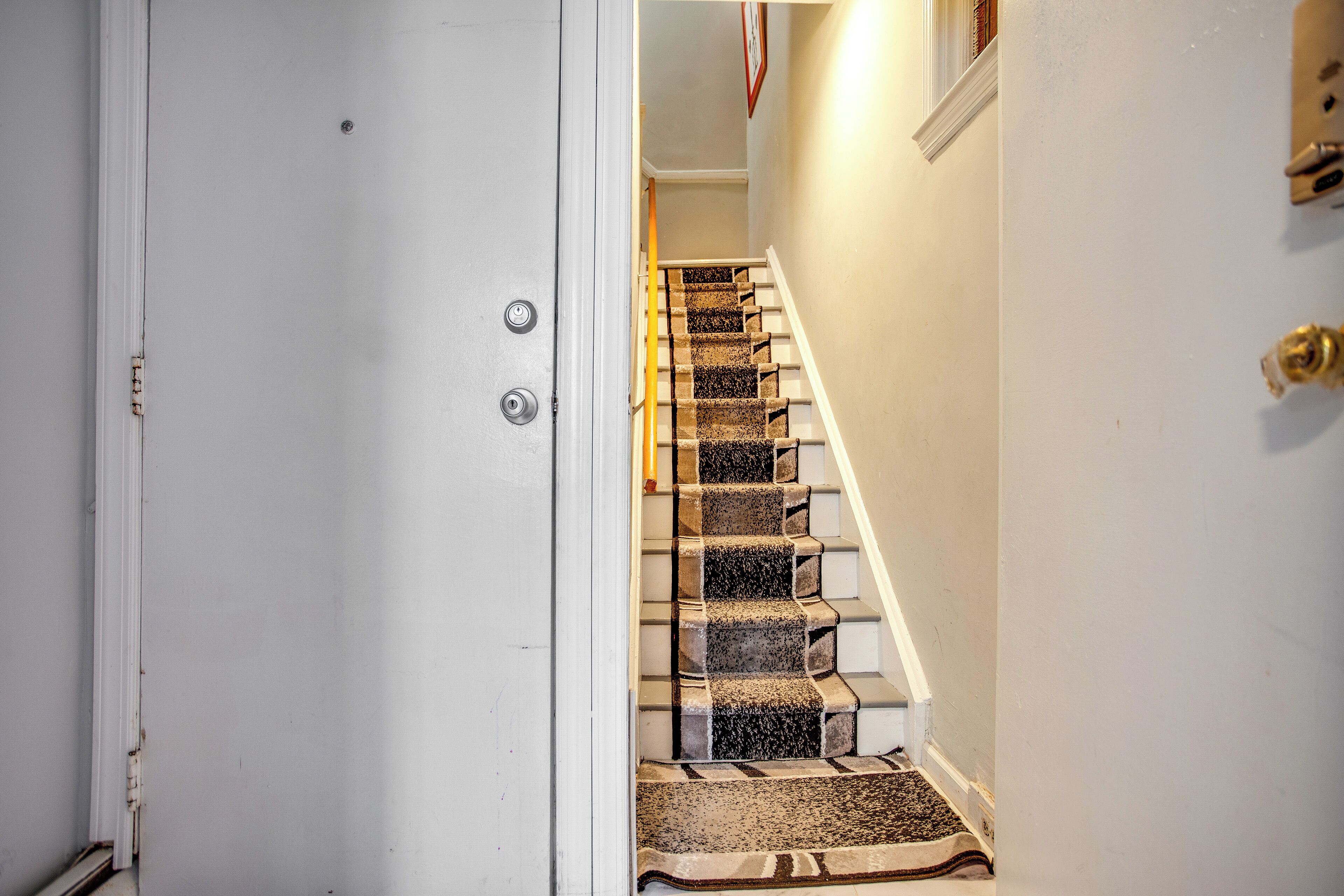 A staircase with carpeted steps leading to a landing.