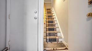 A staircase with carpeted steps leading to a landing.