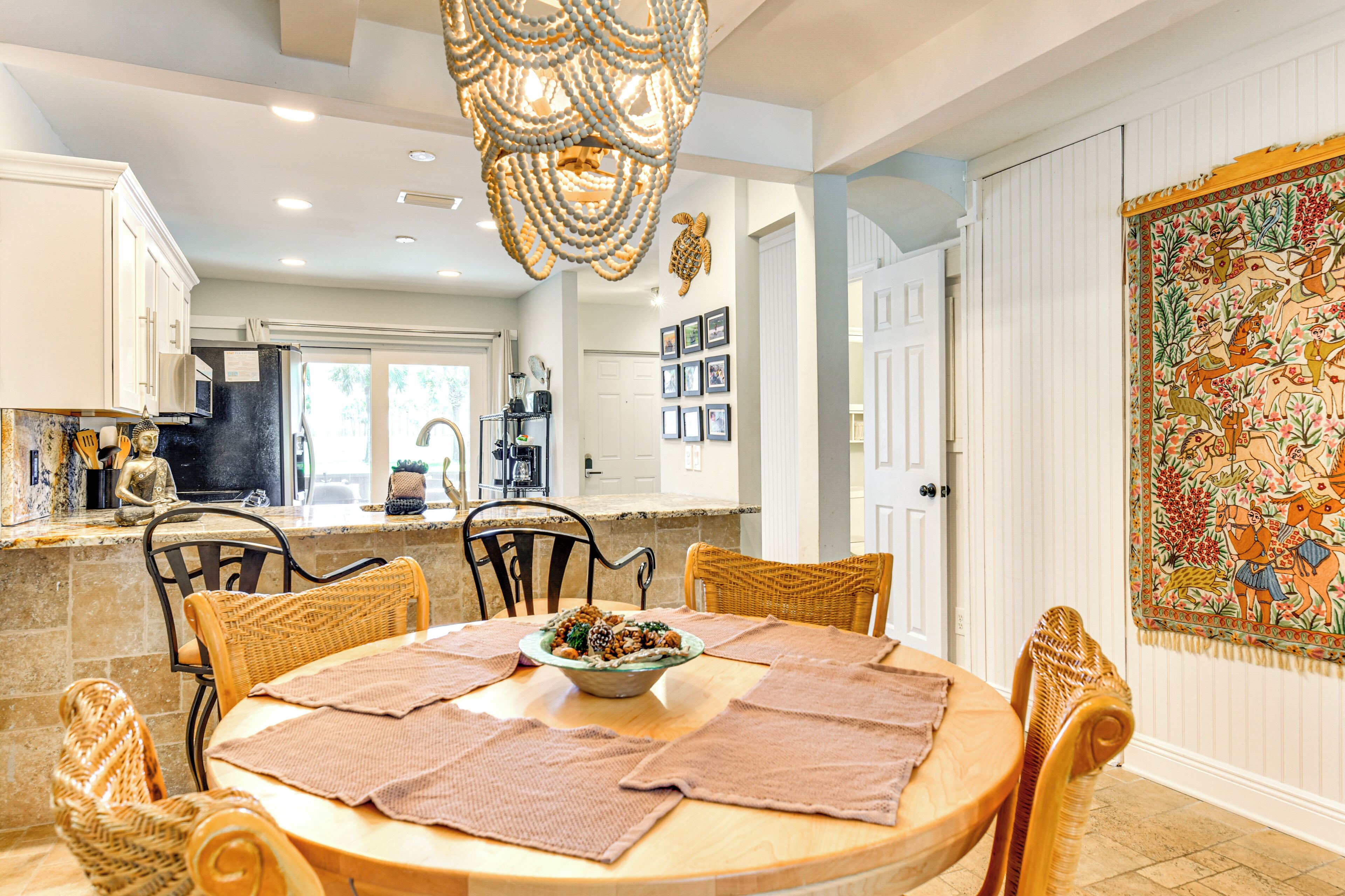 A dining area with a round table, chairs, and a chandelier.