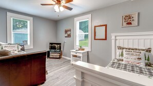 A bedroom with a bed, a dresser, a nightstand, a ceiling fan, and a window. - 2 Mi to Ski Sapphire: Pet-friendly Cashiers Cabin (Cashiers)