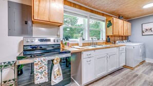 A modern kitchen with wooden cabinets, a built-in oven, a sink, and a dishwasher. - 2 Mi to Ski Sapphire: Pet-friendly Cashiers Cabin (Cashiers)
