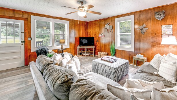 A cozy cabin interior with a wooden interior, a ceiling fan, a television, and a fireplace. - 2 Mi to Ski Sapphire: Pet-friendly Cashiers Cabin (Cashiers)