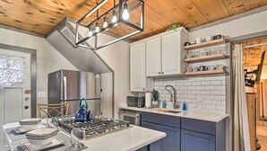 A modern kitchen with a central island, built-in appliances, and a wooden ceiling. - Bemus Point Vintage Suite w/ Soaking Tub & Kitchen (Bemus Point)
