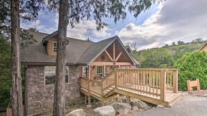 A stone building with a wooden deck and stairs leading to a porch. - Resort Perks! Woodsy Family Retreat Near SDC (Branson West)