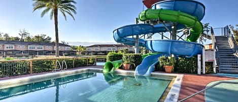 A swimming pool with a water slide structure.
