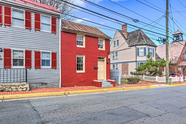 A street view with a red house, a grey house, and a blue house.