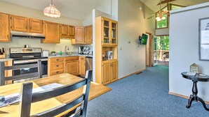 A modern kitchen with wooden cabinets, a dining area with a table and chairs, and a ceiling fan. - Hendersonville 'cantrell Cottage' - Smoky Mtn View (Hendersonville)