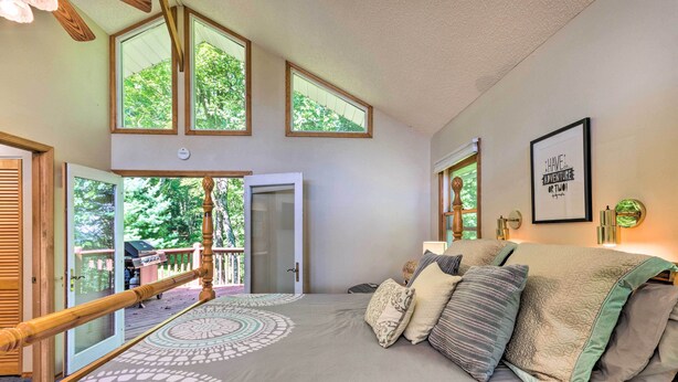 A bedroom with a large bed, multiple windows, and a view of the outdoors. - Hendersonville 'cantrell Cottage' - Smoky Mtn View (Hendersonville)