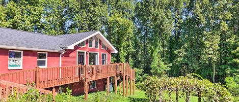 A red building with a wooden deck and a garden.