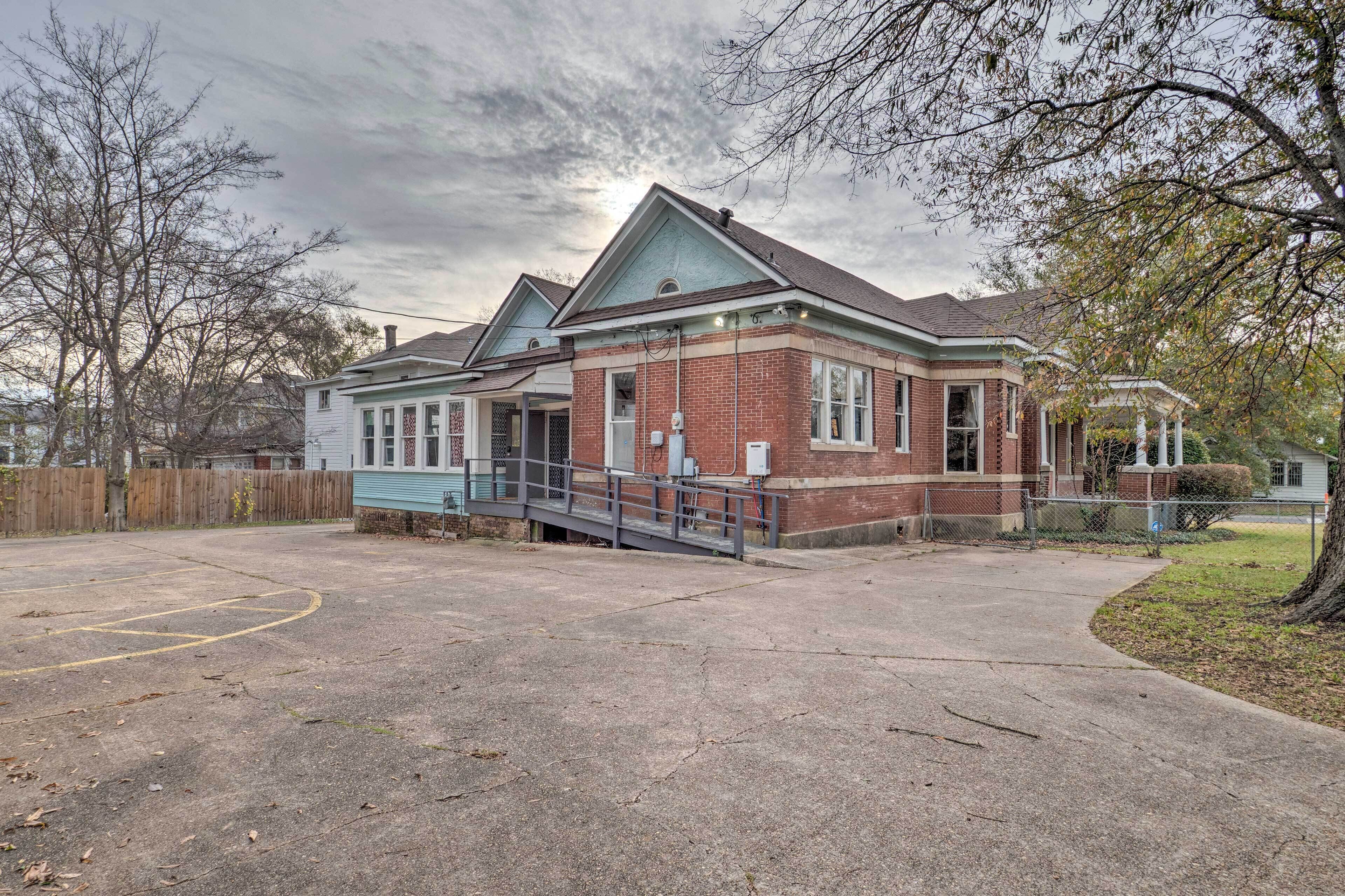 A two-story brick building with a gabled roof and a covered front porch.