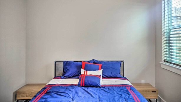 Une chambre à coucher avec un lit, une table de chevet et une fenêtre avec des stores.