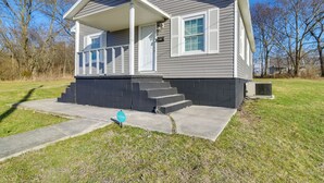 A single-story house with a front porch, a covered entryway, and a small front yard. - Walkable Hopkinsville Home w/ Yard! (Hopkinsville)