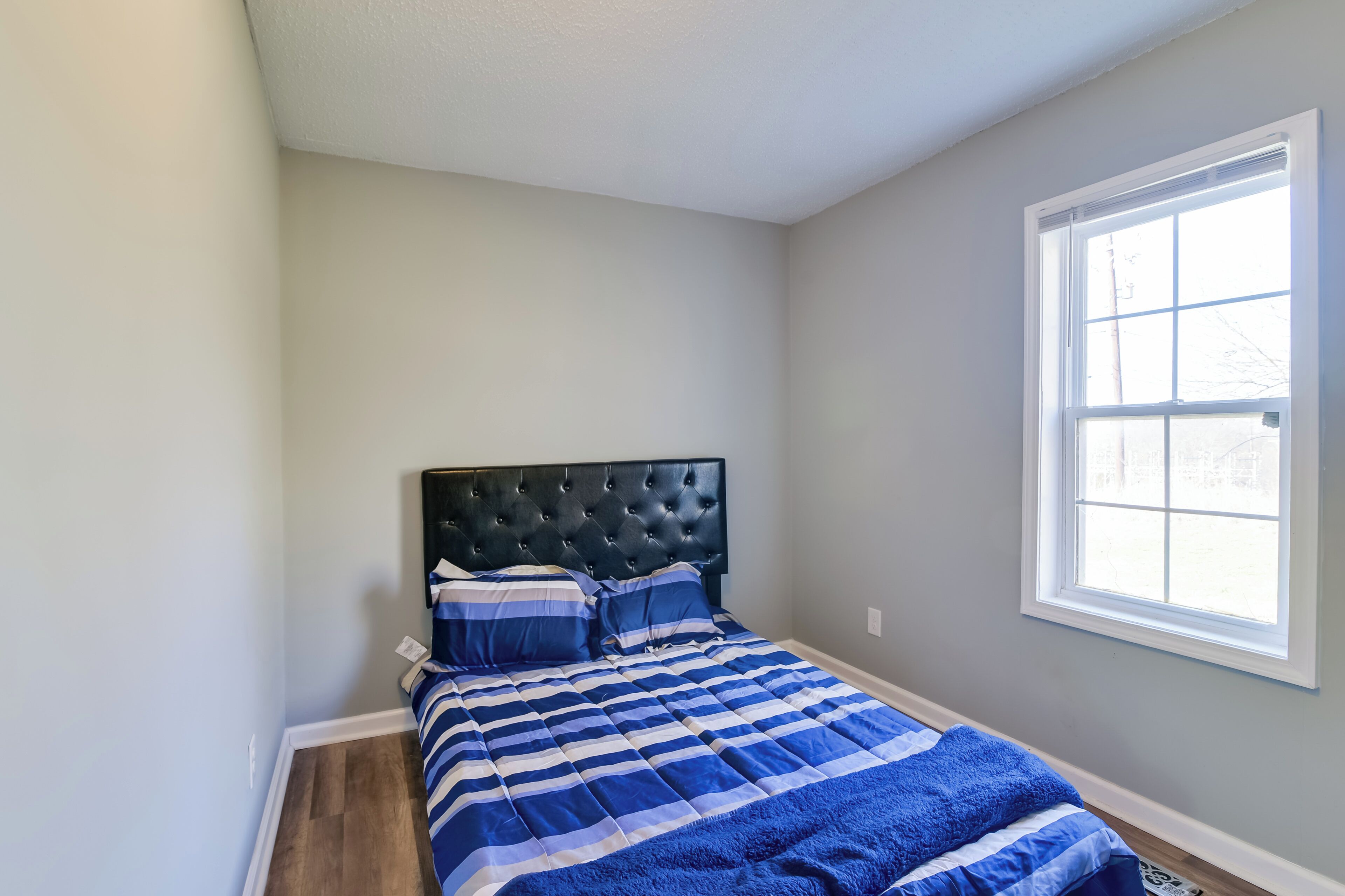 Une chambre à coucher avec un lit, une fenêtre et une porte.