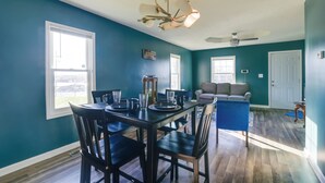 A dining area with a table set for four, a ceiling fan, and a view of the living room. - Walkable Hopkinsville Home w/ Yard! (Hopkinsville)