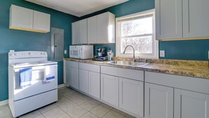 A kitchen with white cabinets, a white stove, a microwave, and a sink. - Walkable Hopkinsville Home w/ Yard! (Hopkinsville)