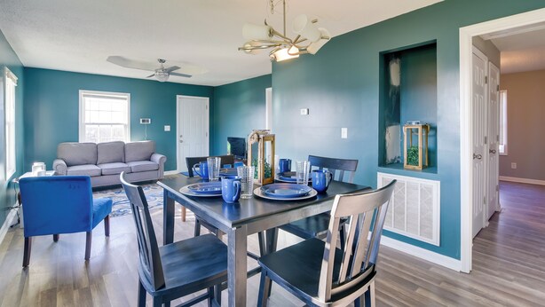 A dining area with a table set for four, a ceiling fan, and teal walls. - Walkable Hopkinsville Home w/ Yard! (Hopkinsville)