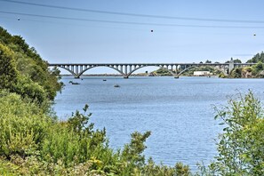 Eine Brücke über einem Fluss mit Booten, umgeben von viel Grün.