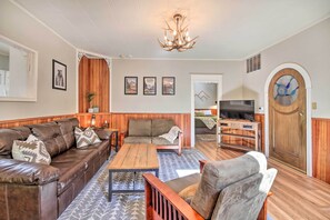 A living room with a brown leather sofa, a wooden coffee table, and a television. - Cozy 'black Bear Retreat' by Mount Rainier! (Ashford)