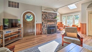 A spacious living room with a fireplace, comfortable seating, and a television.