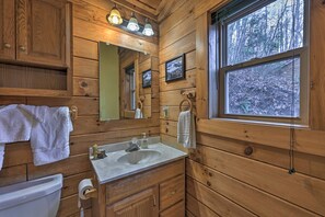 A wooden cabin bathroom with a sink, mirror, and window. - 'bear Den' Cabin: Hot Tub, 4 Mi to Nantahala River (Bryson City)