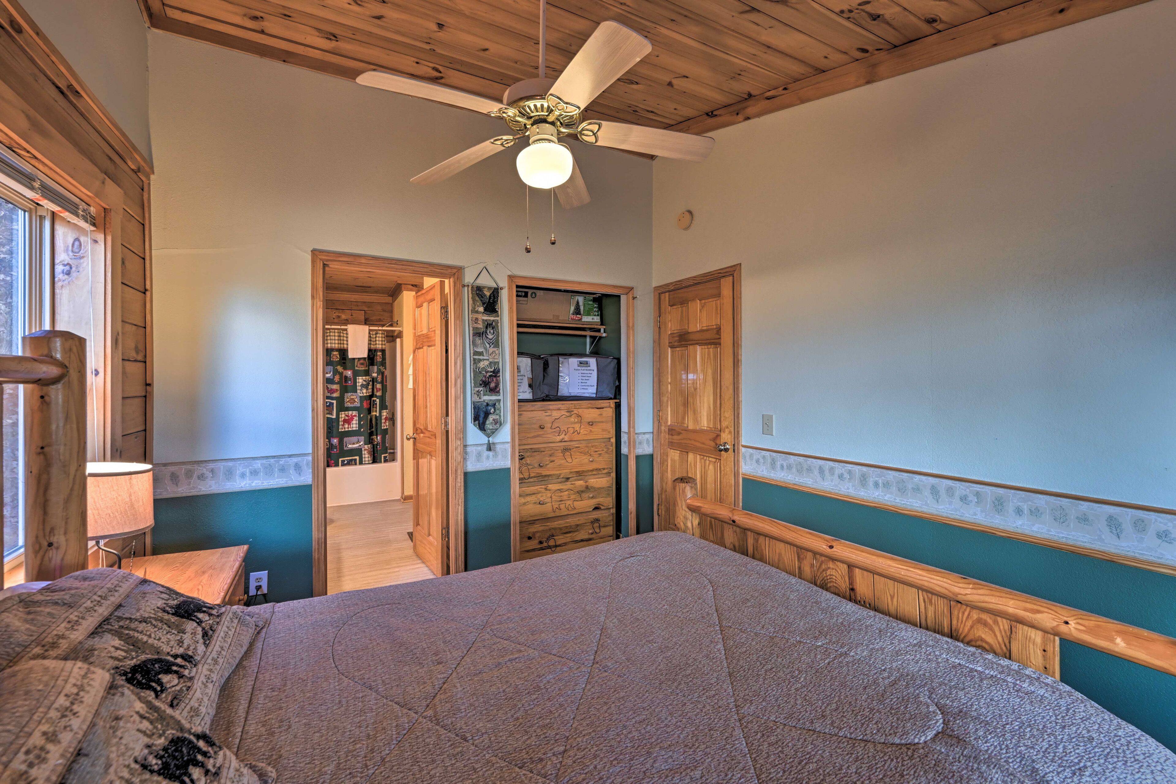 Ein Schlafzimmer mit Bett, Holzboden und Deckenventilator.