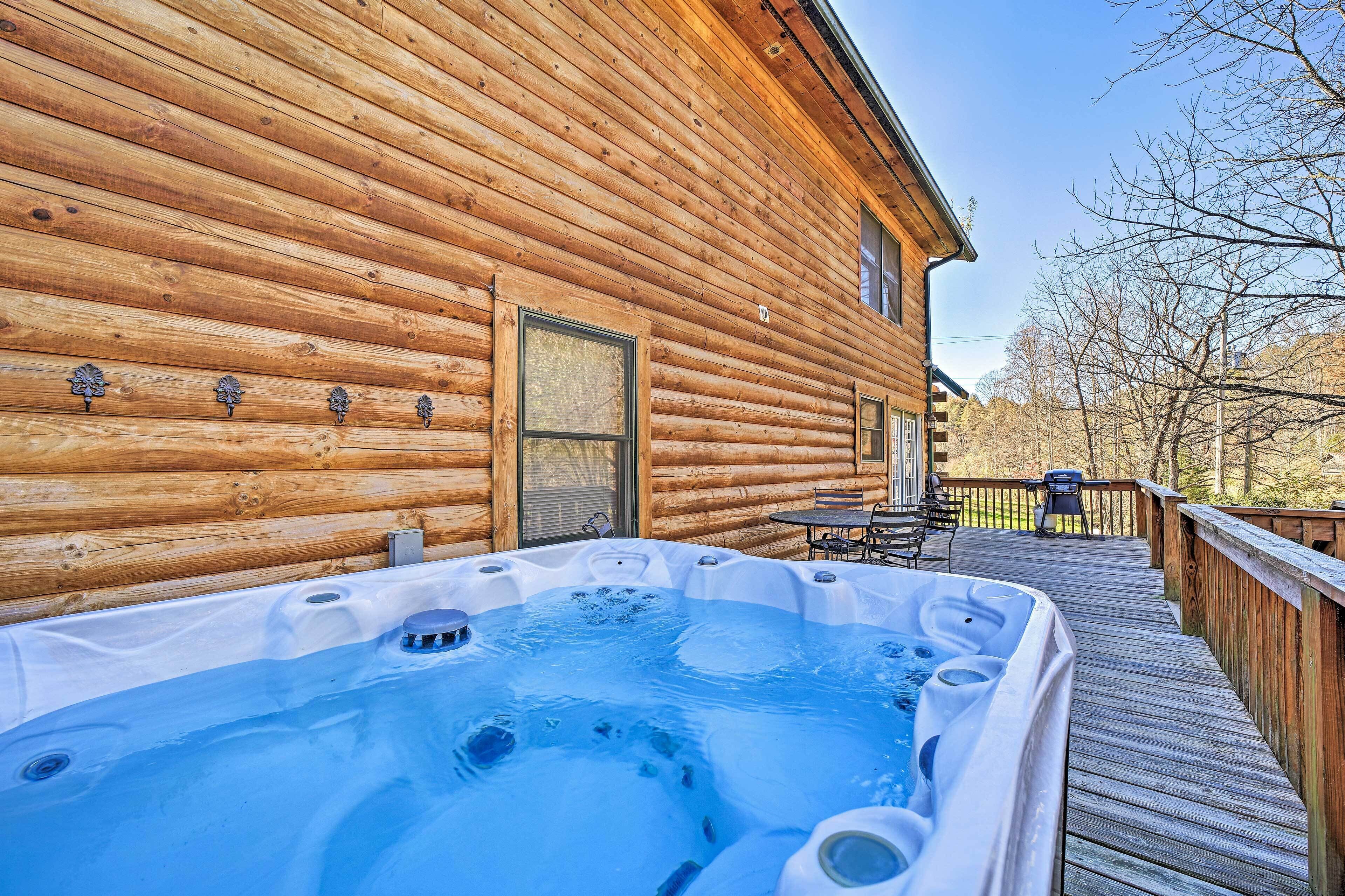 A wooden cabin with a hot tub on a deck.