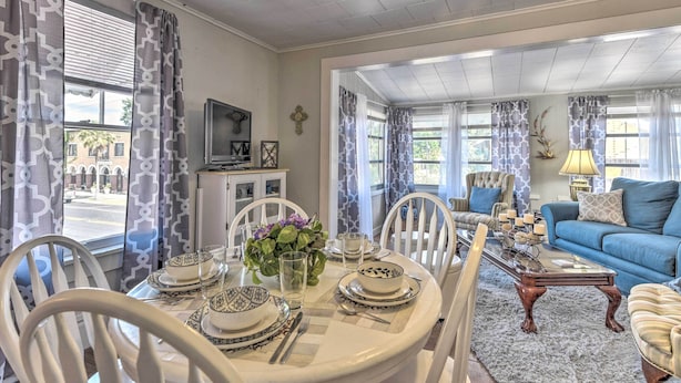 A dining area with a round table set for four, a blue sofa, and a television in the background. - Crescent City Apartment w/ Easy Lake Access! (Crescent City)