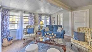 A living room with a blue sofa, striped armchairs, a glass coffee table, and a patterned rug. - Crescent City Apartment w/ Easy Lake Access! (Crescent City)