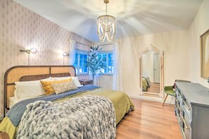 Un dormitorio con una cama grande, una araña, un espejo y un aparador.