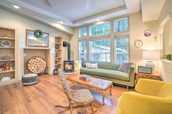 A cozy living room with a fireplace, a sofa, a coffee table, and a rocking chair.