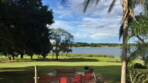 A patio with a grill, chairs, and a view of a lake. - Historic Lakefront Gem ~ 6 Mi to Bok Tower Gardens (Lake Wales)