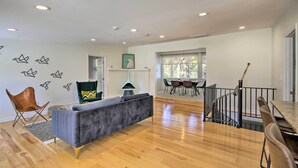 A spacious living area with a grey sofa, wooden flooring, a dining table with chairs, a staircase, and a view of the outdoors. - Anglers Paradise, 1 Mi to Broyles Recreation Area (Townville)