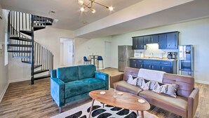 A modern living room with a staircase, two sofas, a coffee table, and a kitchen area with cabinets and appliances. - Anglers Paradise, 1 Mi to Broyles Recreation Area (Townville)