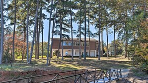 A house surrounded by tall trees, a bridge over a water body, and a grassy area. - Anglers Paradise, 1 Mi to Broyles Recreation Area (Townville)