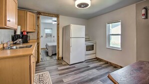 Una pequeña cocina con armarios de madera, un refrigerador, una estufa y una ventana.