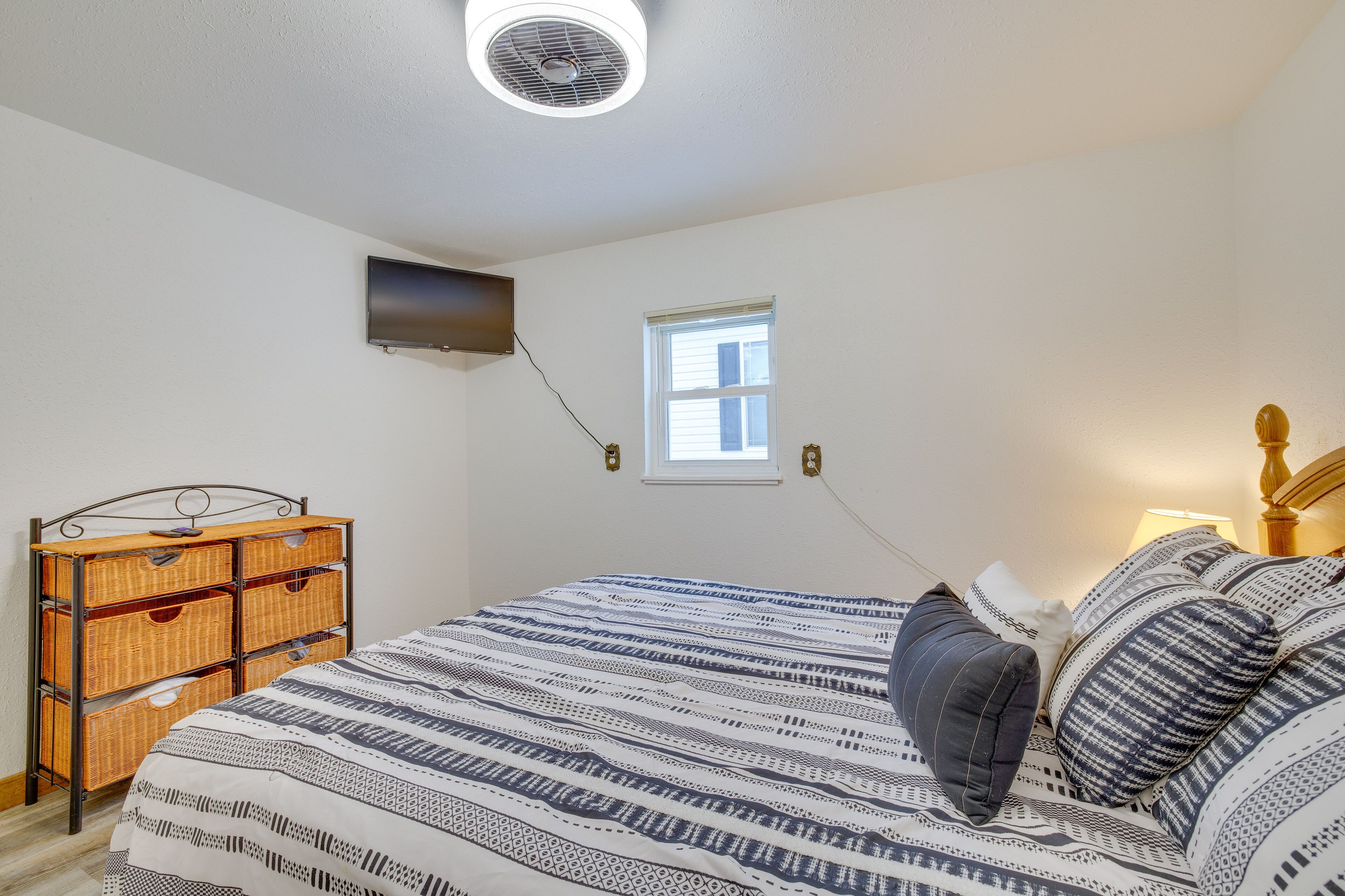 Une chambre à coucher avec un lit, une télévision, une fenêtre et une table de chevet.