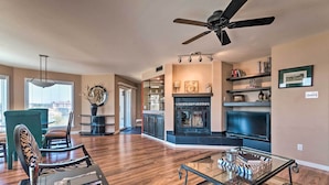 A spacious living room with a fireplace, a television, and a dining area with chairs and a table. - Arkansas Retreat Near Lake Hamilton w/ Pool Access (Hot Springs)