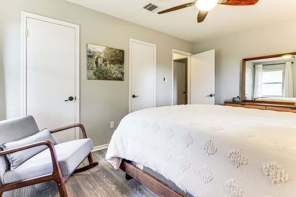 Un dormitorio con una cama grande, una silla y un cuadro en la pared.