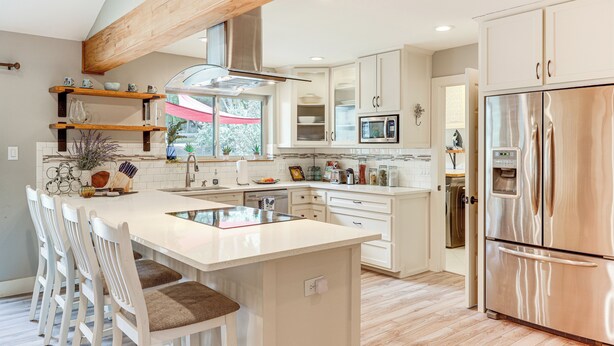 A modern kitchen with a central island, white cabinetry, and stainless steel appliances. - Gorgeous San Marco Home w/ Patio & Grill! (San Marcos)