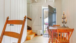 Eine Holztreppe führt zu einem Essbereich mit Tisch und Stühlen.