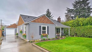 A two-story house with a grey exterior, a brown roof, and a front porch.