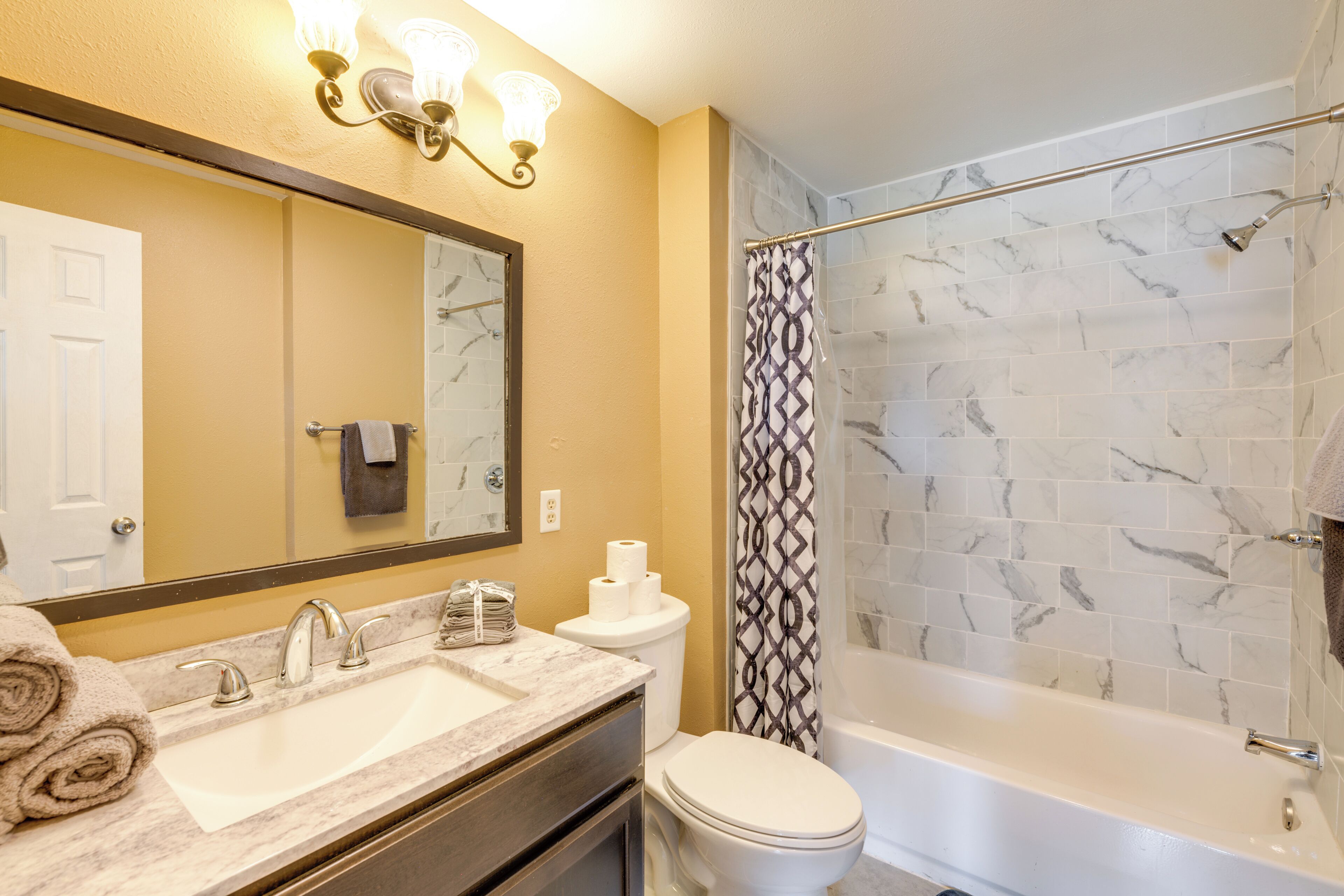 A bathroom with a marble sink, toilet, and bathtub.