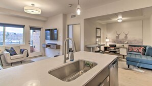 A modern kitchen with a large island, stainless steel appliances, and a built-in dishwasher. - Chic Bozeman Apartment - 1 Block Off West Main St! (Bozeman)