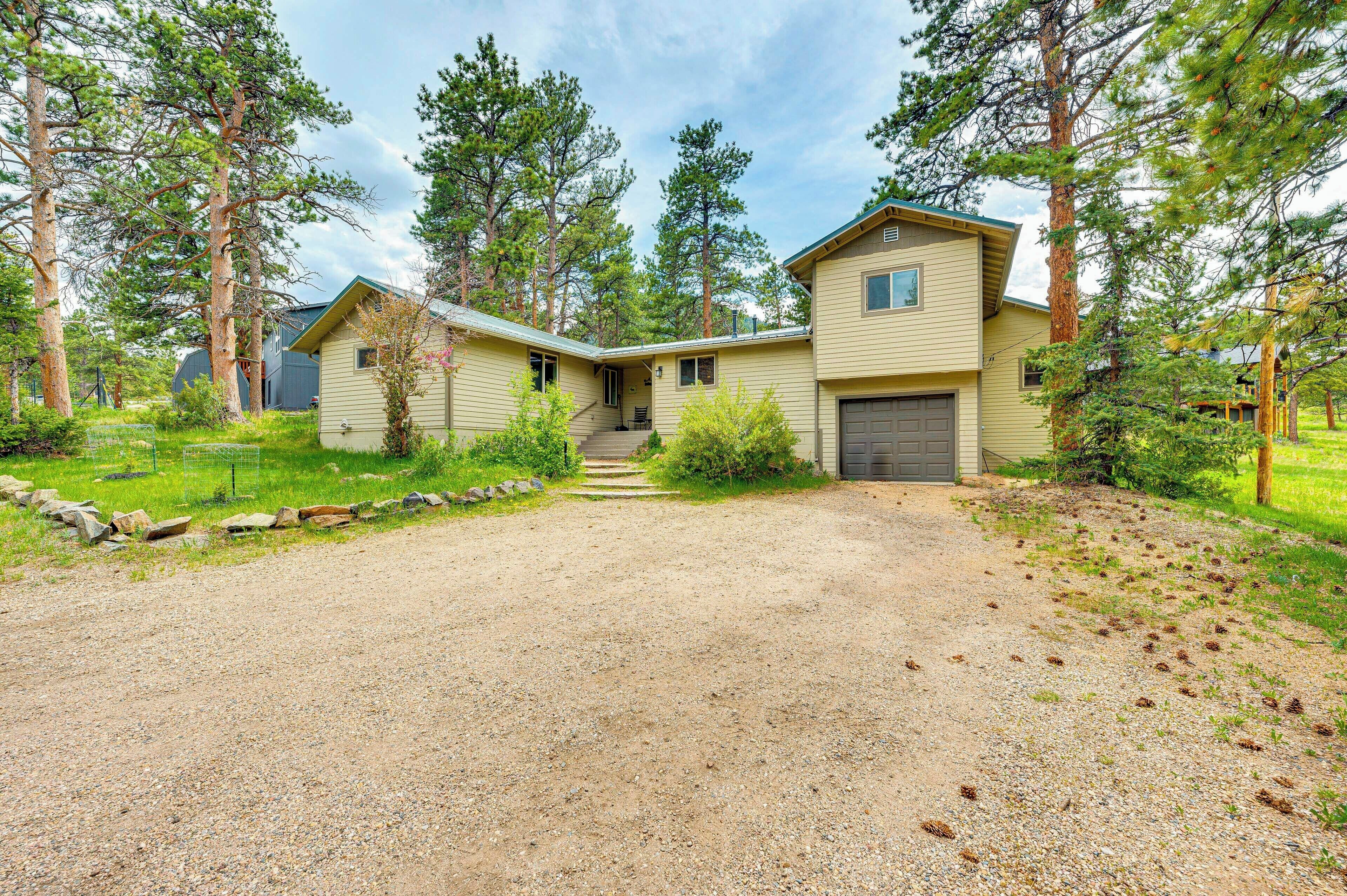 A two-story house with a gravel driveway and a small front porch.