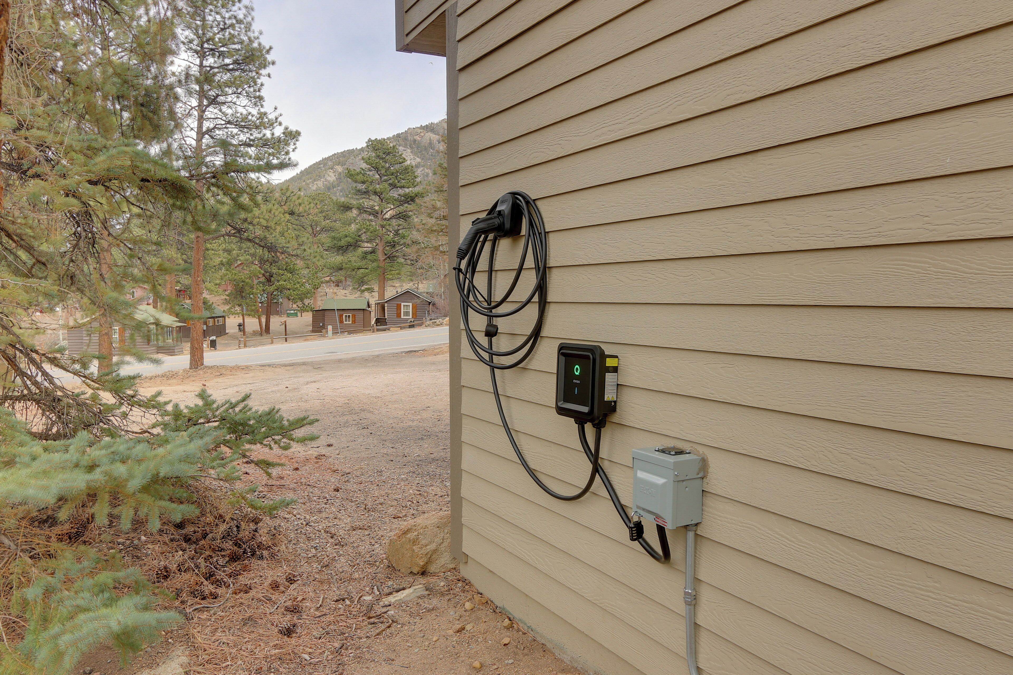 A power outlet on a house exterior with a cable connected to it.
