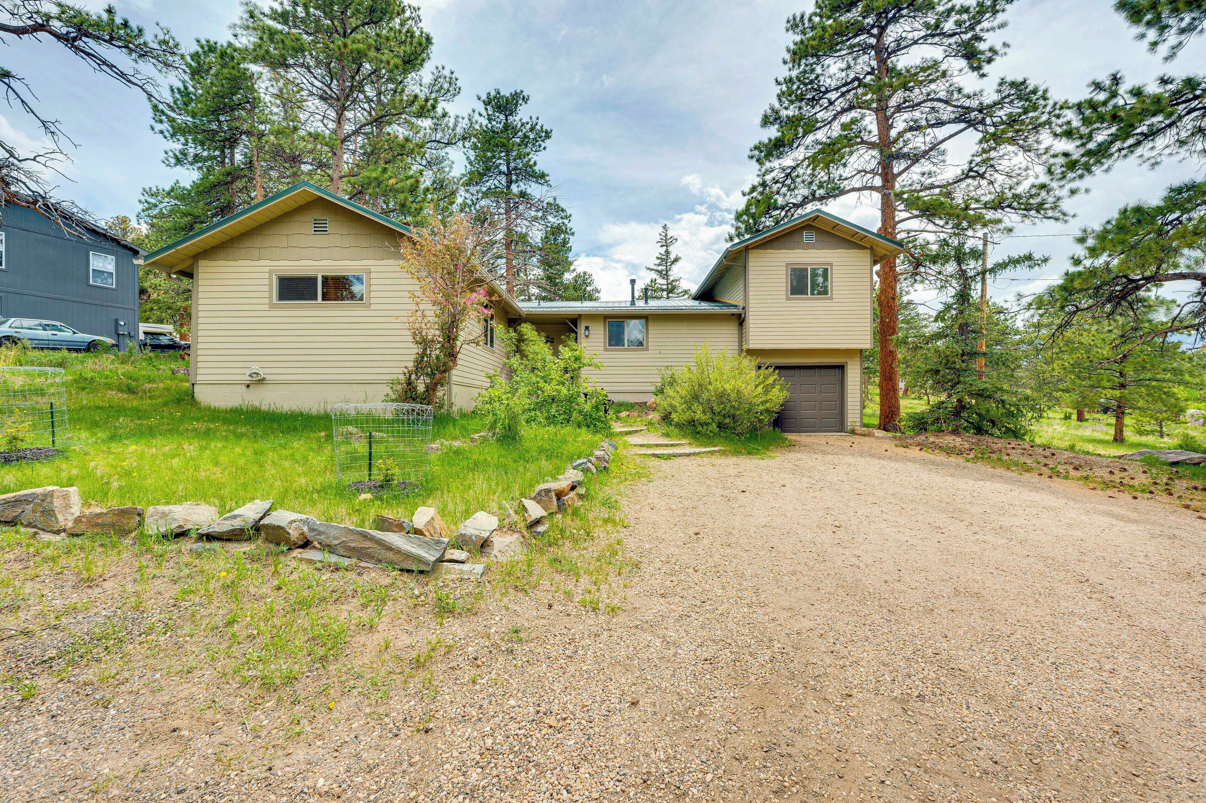 A two-story house with a gravel driveway and a wooden fence.
