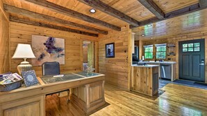 Ein Holzinterieur mit Schreibtisch, Stuhl und Kunstwerken.